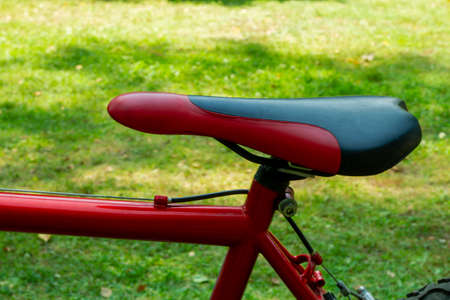side view of bicycle red-black seat with grassy backgroundの写真素材