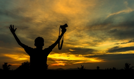 Man silhouette hold the camera with sunset background の写真素材