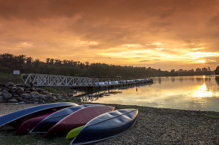 A bunch of kayaks stranded with a orange sunset backgroundの写真素材