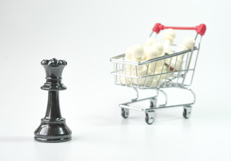 Black queen with white pawn inside toy trolley backgroundの写真素材