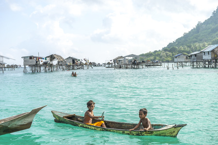 SABAH, MALAYSIA - AUGUST 17, 2016 : Unidentified Bajau Laut kids on a boat in Bodgaya Island, Sabah, Malaysia. They lived in a house built on stilts in the middle of sea, boat is the main transportation here.のeditorial素材