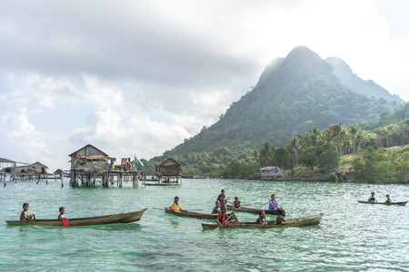 SABAH, MALAYSIA - AUGUST 17, 2016 : Unidentified Bajau Laut kids on a boat in Bodgaya Island, Sabah, Malaysia. They lived in a house built on stilts in the middle of sea, boat is the main transportation here.のeditorial素材