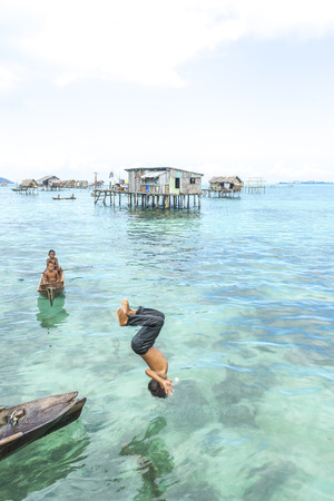 SABAH, MALAYSIA - AUGUST 15, 2016 : Unidentified Bajau Laut kids on a boat in Bodgaya Island, Sabah, Malaysia. They lived in a house built on stilts in the middle of sea, boat is the main transportation here.のeditorial素材