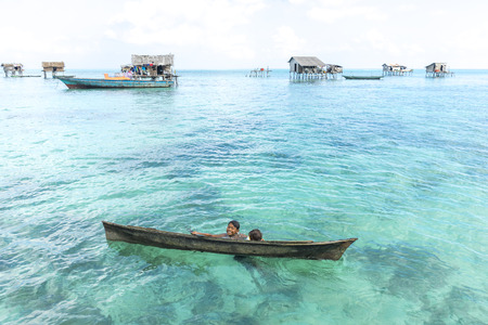SABAH, MALAYSIA - AUGUST 15, 2016 : Unidentified Bajau Laut kids on a boat in Bodgaya Island, Sabah, Malaysia. They lived in a house built on stilts in the middle of sea, boat is the main transportation here.のeditorial素材