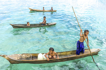 SABAH, MALAYSIA - AUGUST 15, 2015: Unidentified Bajau Laut kids on a boat in Bodgaya Island, Sabah, Malaysia. They lived in a house built on stilts in the middle of sea, boat is the main transportation hereのeditorial素材