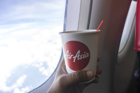 SABAH, MALAYSIA - AUGUST 17, 2015 : A coffee cup near window inside AirAsia Airplane with natural lighting.のeditorial素材