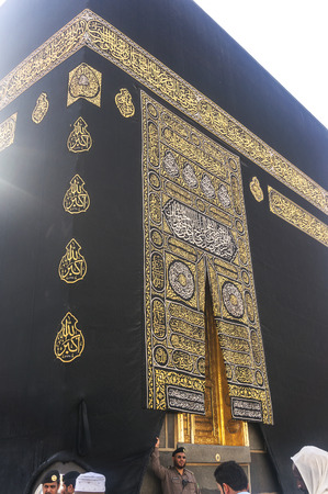 MAKKAH - MAR 14 : A close up view of kaaba door and the kiswah (cloth that covers the kaaba) at Masjidil Haram on March 14, 2015 in Makkah, Saudi Arabia. The door is made of pure gold.のeditorial素材