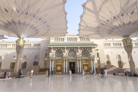 MEDINA - MARCH 06 : Pilgrims walk underneath giant umbrellas at Nabawi Mosque compound on March 06,...