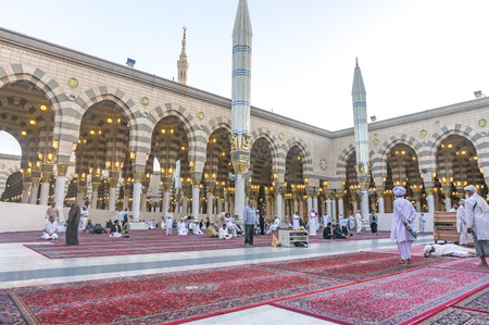 MEDINA, SAUDI ARABIA - MARCH 09, 2015 : Pilgrims resting and reading koran after fajr pray inside...