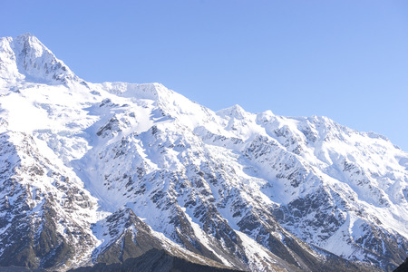 View of top mountain cook with white snow and rock texture.