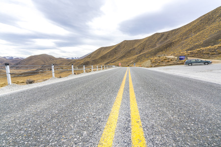 Asphalt road with lenticular cloud at south of New Zealandの写真素材