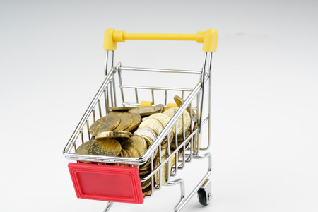 Toy trolley and coin with white background. Financial concept.の写真素材
