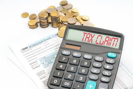 Calculator with red text on screen and tax form.の写真素材