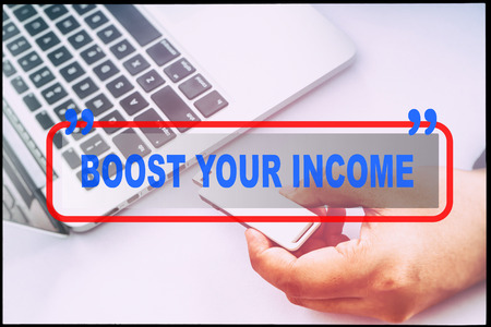 Hand and text  BOOST YOUR INCOME with vintage background. Technology concept.