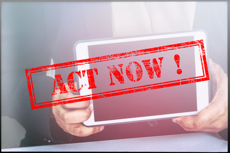 Hand with red grunge stamp with text "ACT NOW". Technology concept.の写真素材