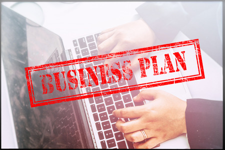 Hand with red grunge stamp with text BUSINESS PLAN. Technology concept.