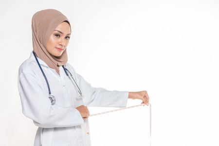 Hijab medical doctor with measurement tape. Diet concept.の写真素材