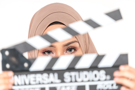 Hijab girl holding a clapper board. Filmmaking or film production conceptの写真素材