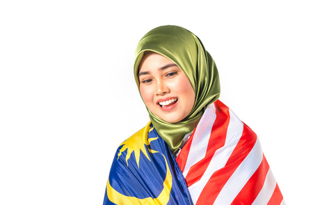 Hijab teenager holding malaysia flag for independence day celebration.の写真素材