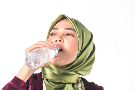 Veiled teenager drinking with healthy concept.の写真素材