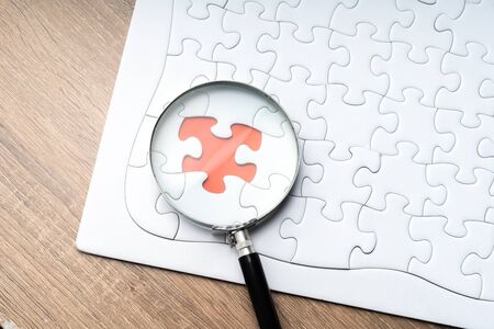 Magnifier glass and jigsaw puzzle background with education concept.の写真素材