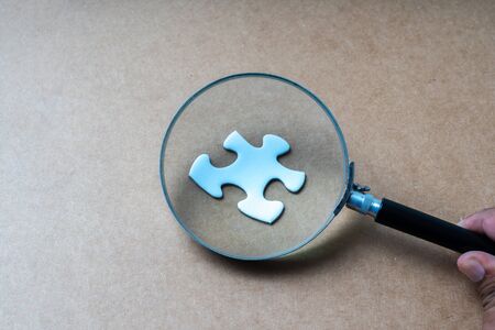 Magnifier glass and jigsaw puzzle background with education concept.の写真素材