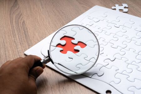 Magnifier glass and jigsaw puzzle background with education concept.の写真素材