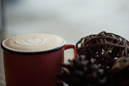 Latte coffee with heart latte art and cozy background.の写真素材