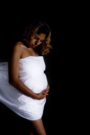 Young mother to be contemplating the future in low key photo.の写真素材