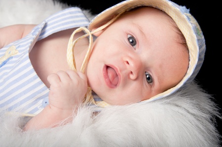 Curious baby boy in hat with mouth openの写真素材