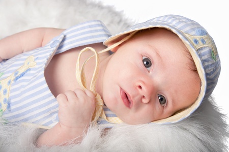 Curious baby boy in hat stares aheadの写真素材