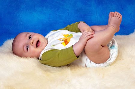 Happy child on the white carpet and the blue mosaic backgroundの写真素材