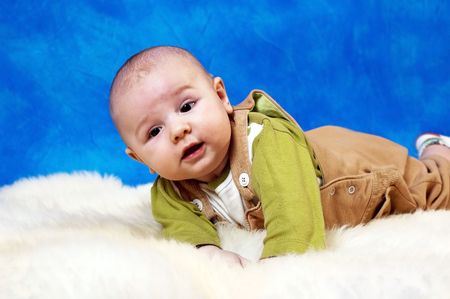 Happy child on the white carpet and the blue mosaic background