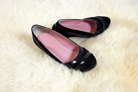 Pair of black shoes on the sheep's white skinの写真素材