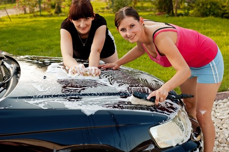 Adult cleaning her car outsideの写真素材