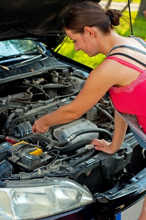 Young woman repairing her carの写真素材