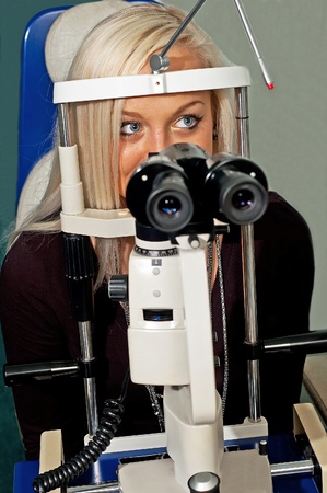 Young woman examining the eyesight in the optician'sの写真素材