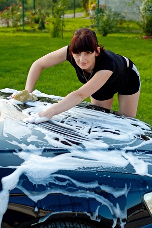 Adult cleaning her car outsideの写真素材