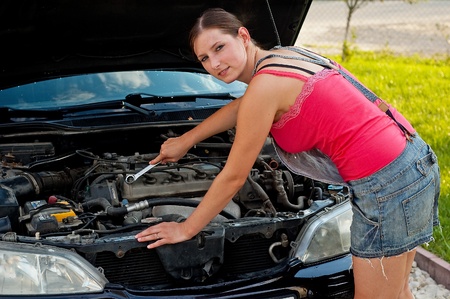 Young woman repairing her carの写真素材