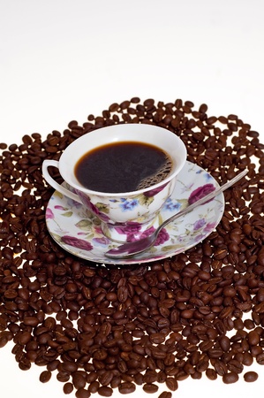 grains of the coffee with the cup of the hot coffee on the white backgroundの写真素材