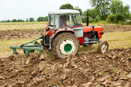 ploughing field on old tractor in southern Polandの写真素材