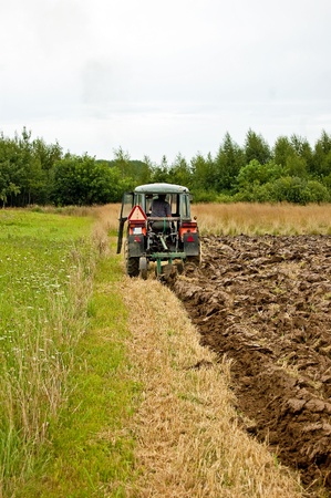 ploughing field on old tractor in southern Polandの写真素材