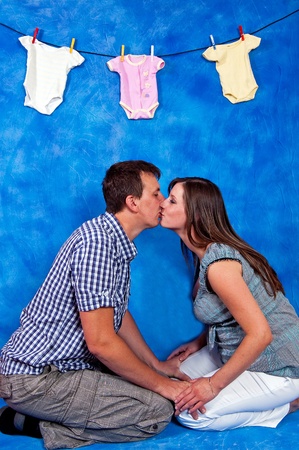 prospective young parents kissing on blue mosaic backgroundの写真素材