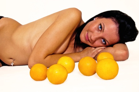 Naked girl from fruits of the orange lying on the white backgroundの写真素材