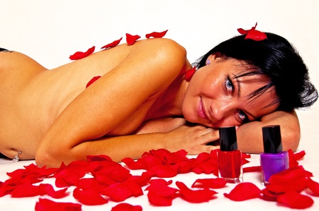 Rose petals and a naked woman on a white backgroundの写真素材