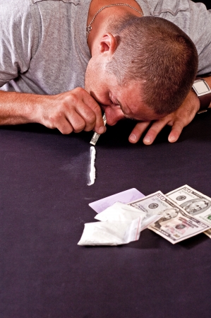 Drug addict injecting himself in the gloomy basementの写真素材