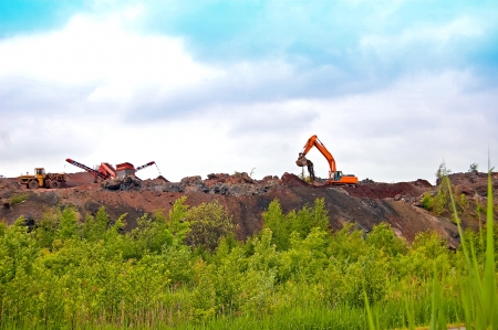 Heavy equipment working on the construction of the road on the embankmentの写真素材