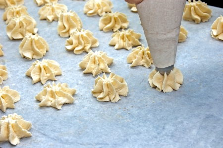 Production of biscuits by hand in the bakery, pastry bag squeezedの写真素材
