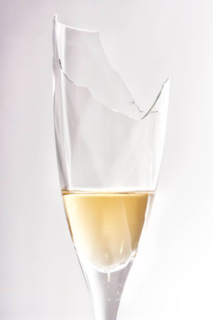 Broken champagne glass, still containing champagne.の写真素材