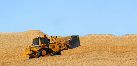 Earth mover driving on wood chips